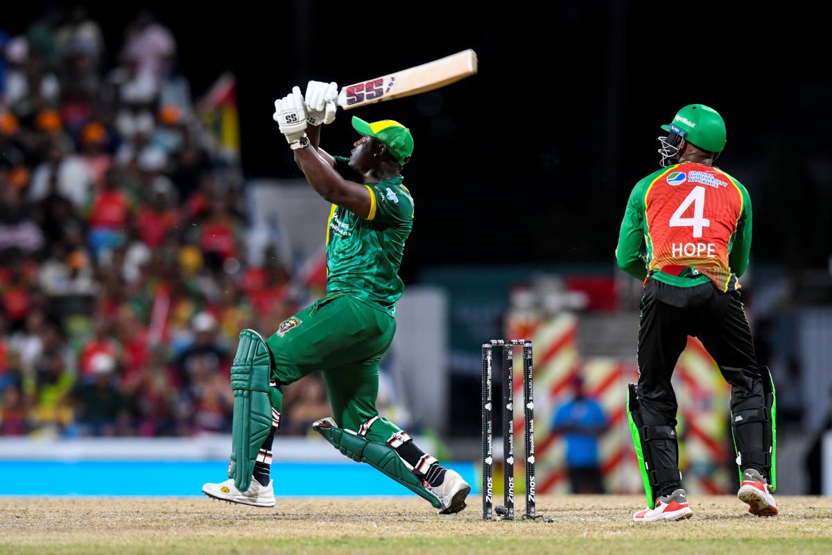 Jamaica Kingsmen captain, Rovman Powell (left), swings for the fences during a Republic Bank Caribbean Premier League Qualifier against the Guyana Amazon Warriors on Friday night. Amazon Warriors wickeetkeepeer Shai Hope looks on.