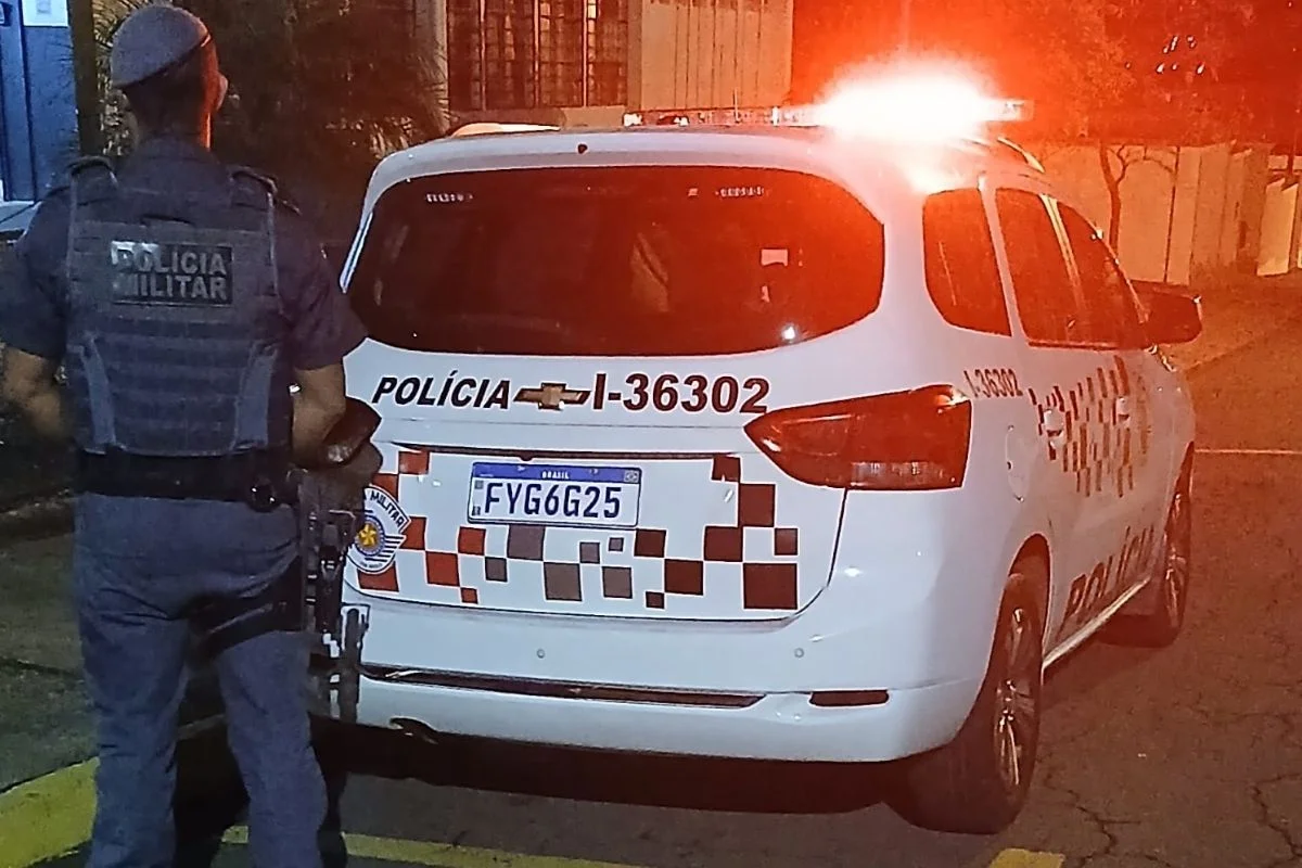 Foto colorida mostra viatura em frente à delegacia onde motociclista permaneceu preso.