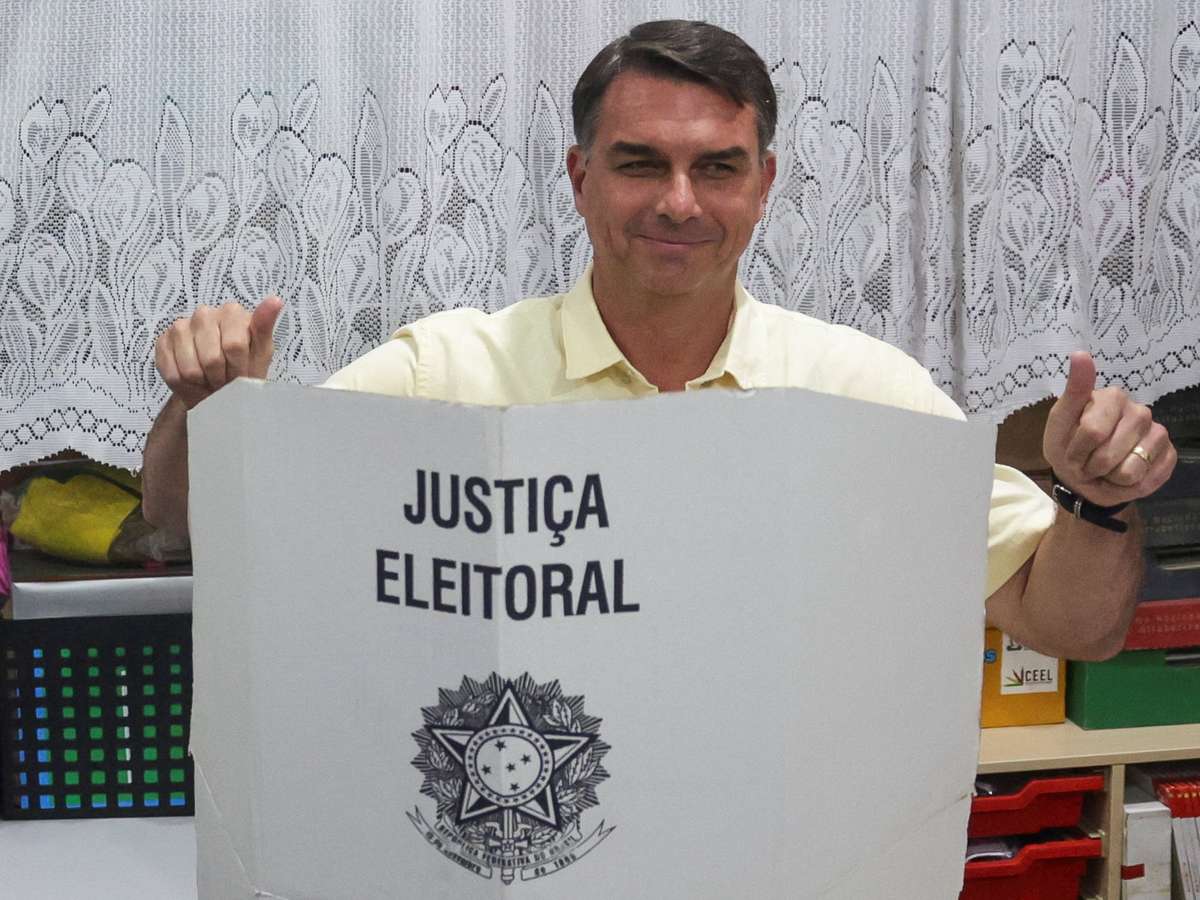Tumulto, celebração e provocações de eleitores do PT: Flávio Bolsonaro vota em escola no RJ